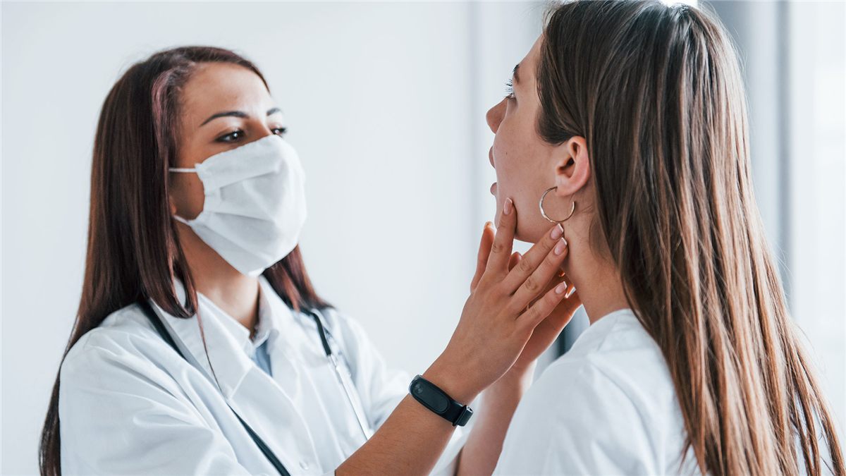 Profissional examinando a garganta de uma paciente