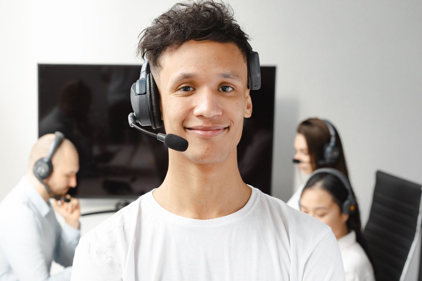 Atendente sorrindo com fone de ouvido na central de atendimento