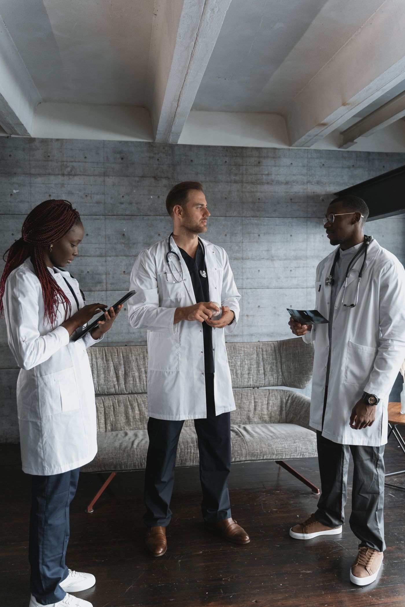 Três médicos conversando em pé no hospital